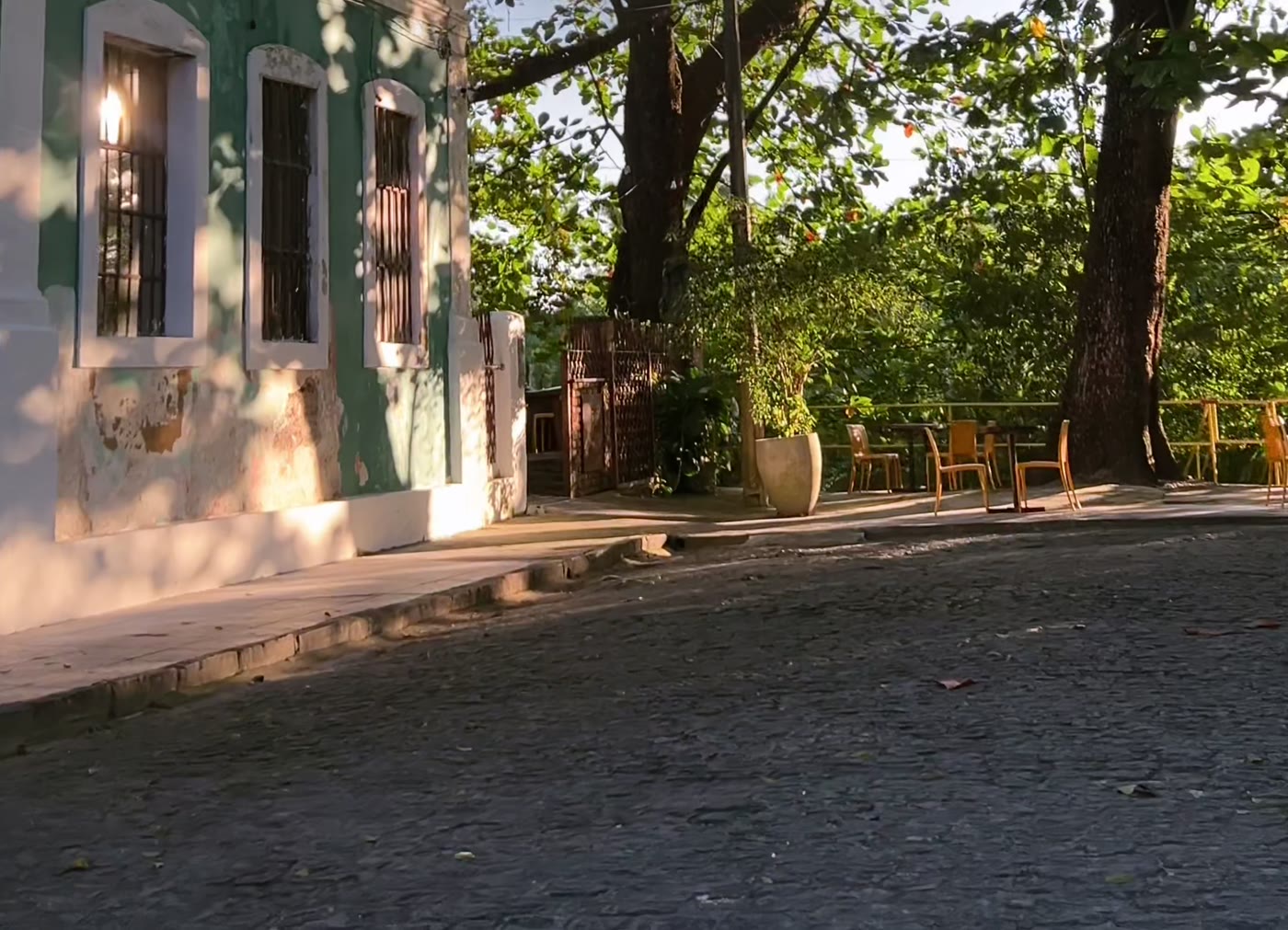 A rua de paralelepípedo do Poço da Panela, com o casarão histórico e as cadeiras do Terraço no fim do dia.